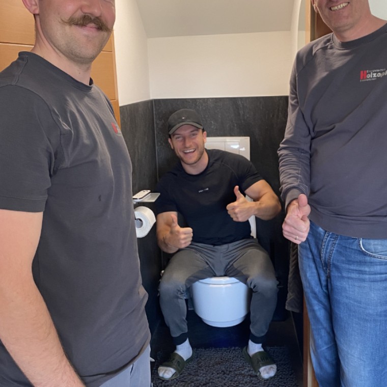 Erstes Probesitzen auf dem neuen Geberit AquaClean Mera Dusch-WC. Professionell installiert von Dieter Holzapfel (rechts im Bild) und Patrick Hofer (links im Bild) von der Firma Holzapfel in Bürmoos. (c) Sascha Huber Erstes Probesitzen auf dem neuen Geberit AquaClean Mera Dusch-WC. Professionell installiert von Dieter Holzapfel (rechts im Bild) und Patrick Hofer (links im Bild) von der Firma Holzapfel in Bürmoos. (c) Sascha Huber