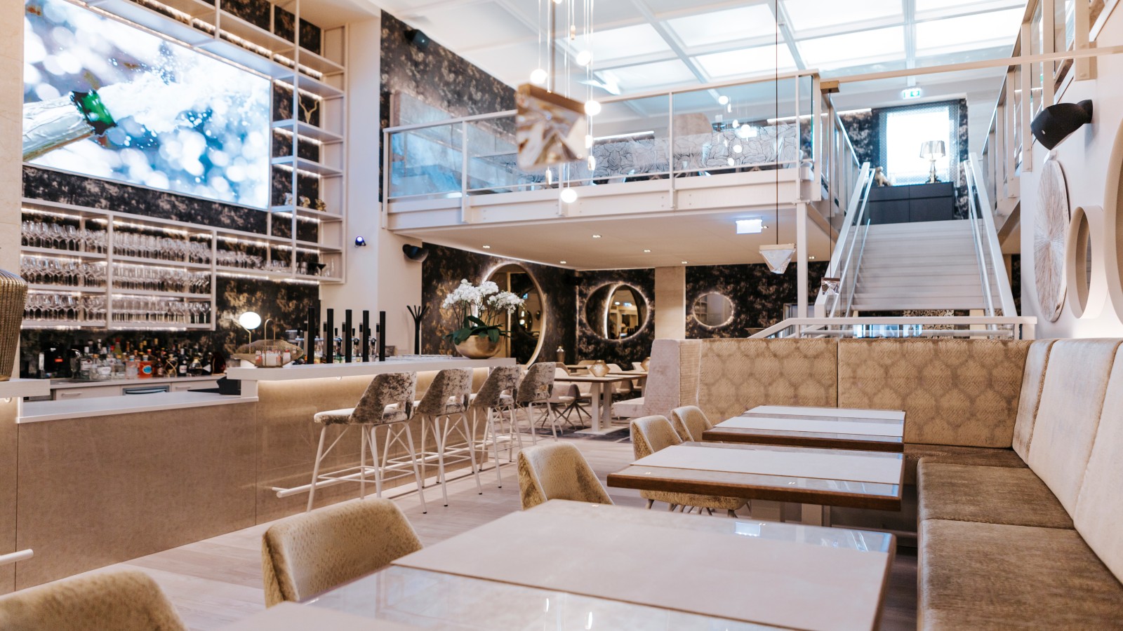 Im ursprünglichen Bankgebäude wurde eine zweite Ebene eingezogen. Die neu entstandene Galerie bietet nicht nur mehr Platz für Gäste, sondern einen tollen Ausblick auf den großzügigen Barbereich mit Videowand. Fotocredit: Markt.Spiel Im ursprünglichen Bankgebäude wurde eine zweite Ebene eingezogen. Die neu entstandene Galerie bietet nicht nur mehr Platz für Gäste, sondern einen tollen Ausblick auf den großzügigen Barbereich mit Videowand. Fotocredit: Markt.Spiel