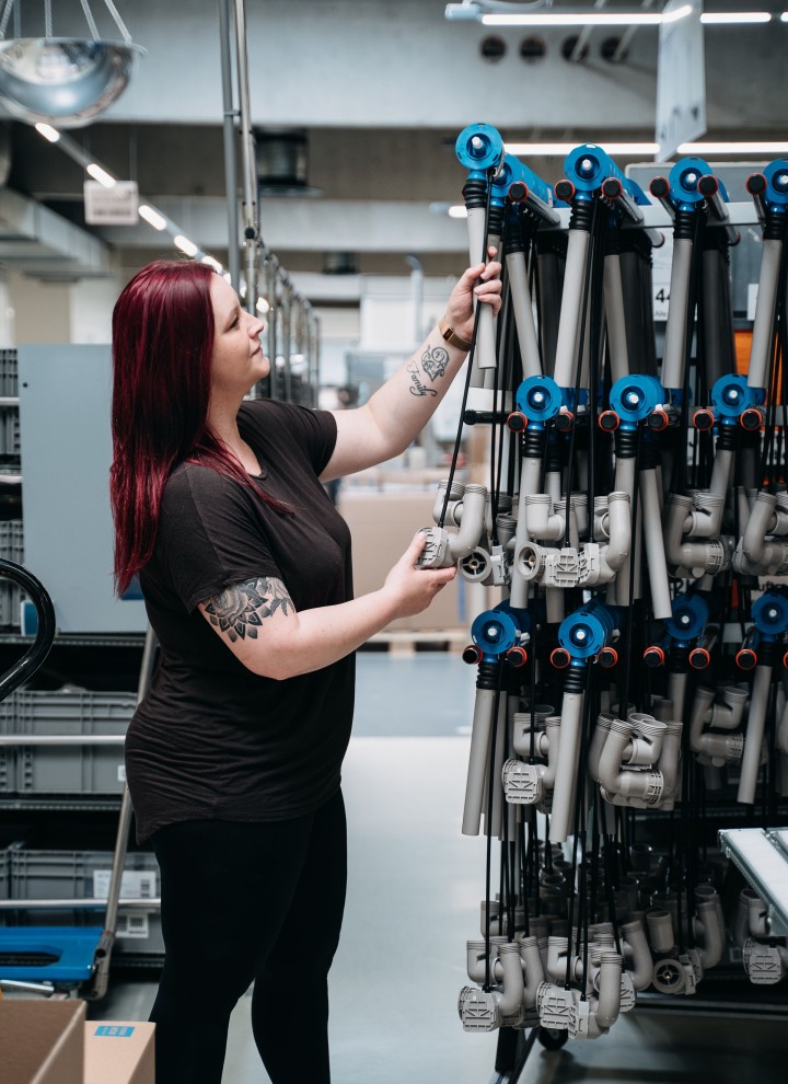 Sarah Berner mit Wannenabläufen aus ihrer Produktionslinie. (c) Geberit / Tobias Singer