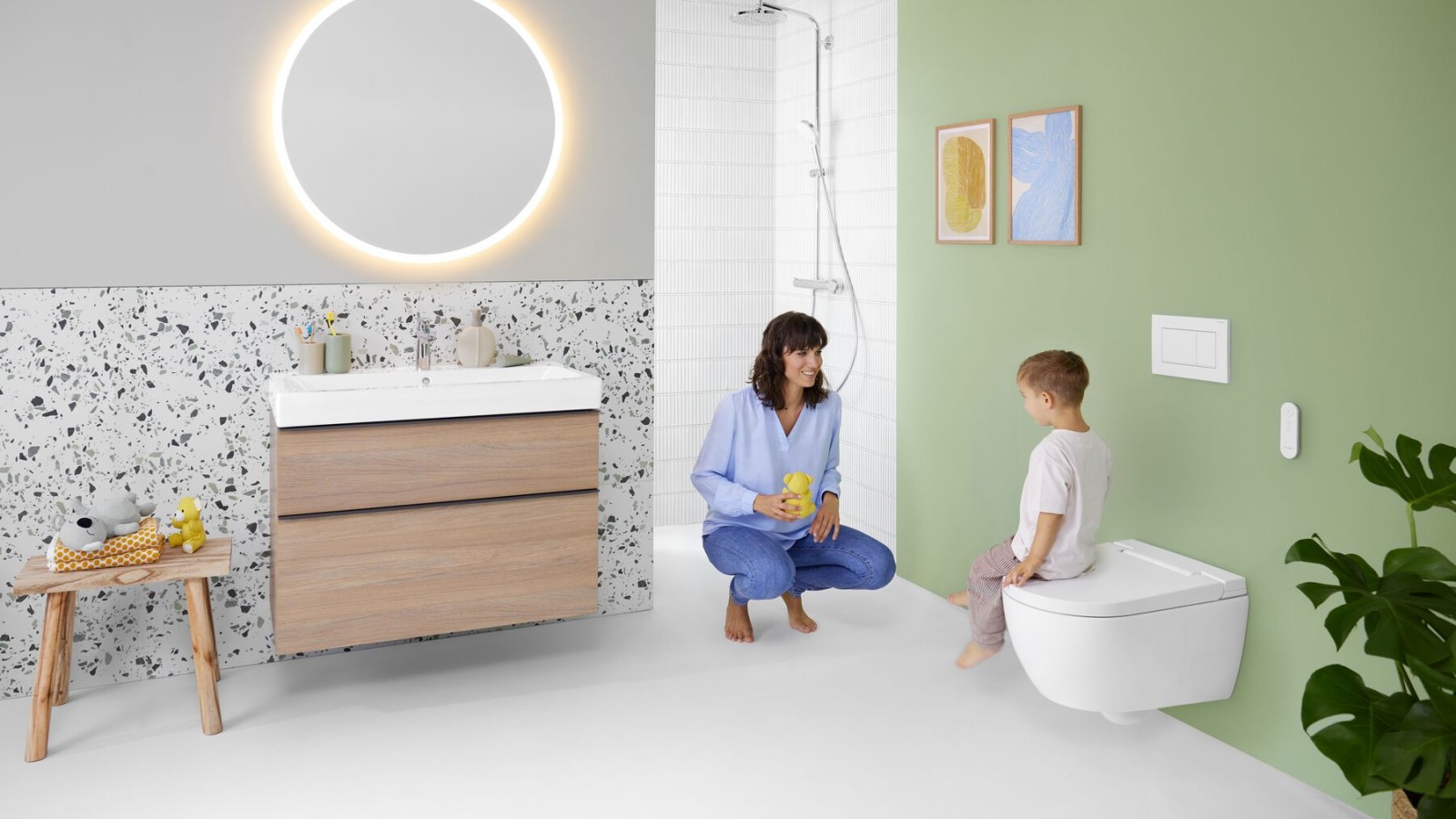 Frau und Kind in einem farbenfrohen Badezimmer mit Geberit Option Spiegel und Geberit AquaClean Alba Frau und Kind in einem farbenfrohen Badezimmer mit Geberit Option Spiegel und Geberit AquaClean Alba