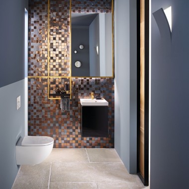 Blick in ein modernes Gäste-WC mit einem Acanto WC und einem Acanto Waschtisch vor einer Mosaik-Rückwand