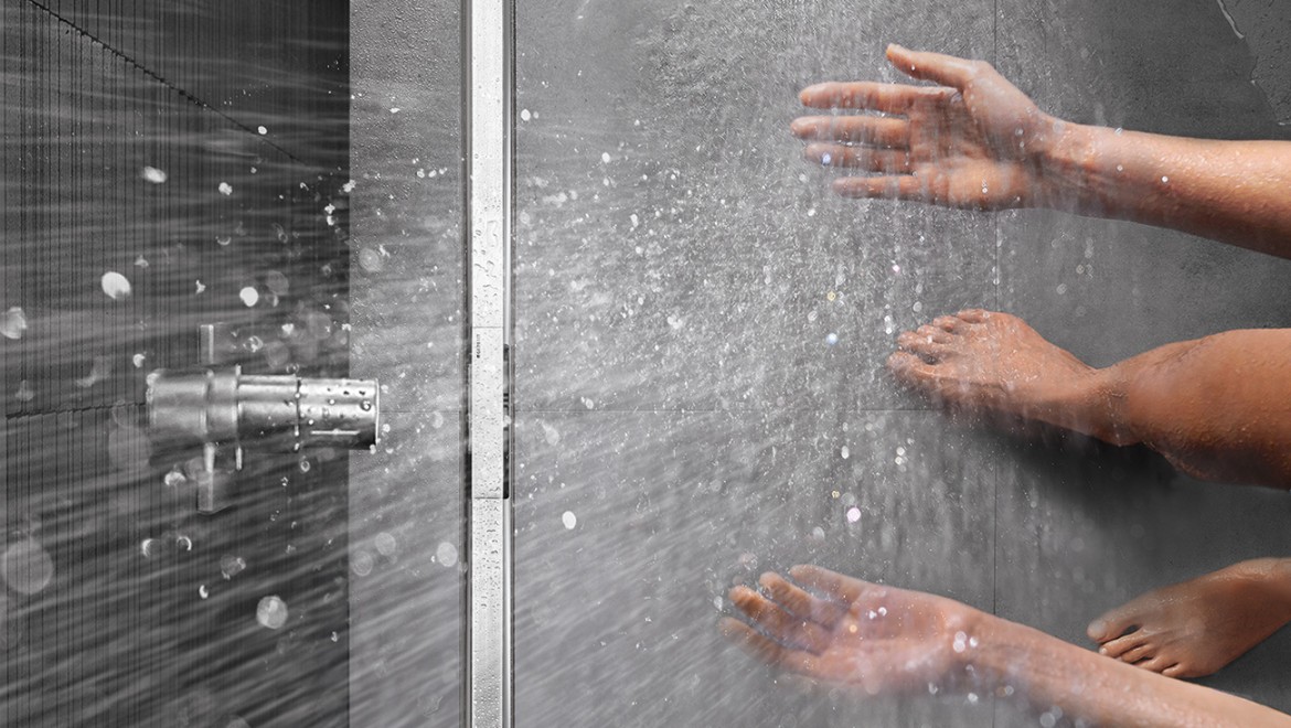Person duscht in bodenebener Dusche, die mit der Duschrinne Geberit CleanLine ausgestattet ist