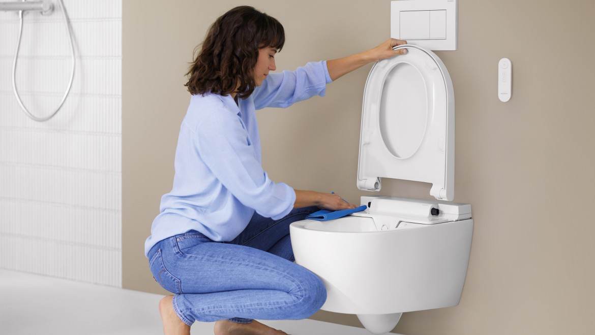 Frau reinigt Geberit AquaClean Alba Frau reinigt Geberit AquaClean Alba