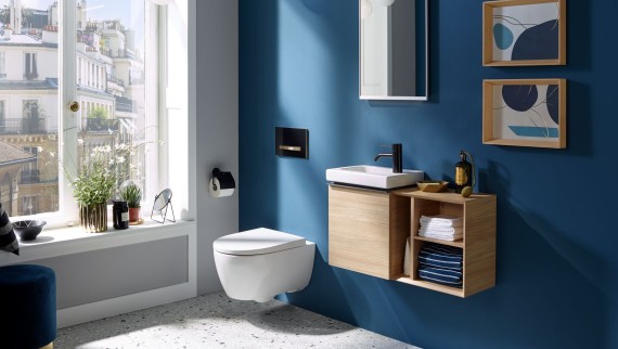 Durch ein Fenster fällt Licht in ein Gäste-WC mit dunkelblauer Rückwand