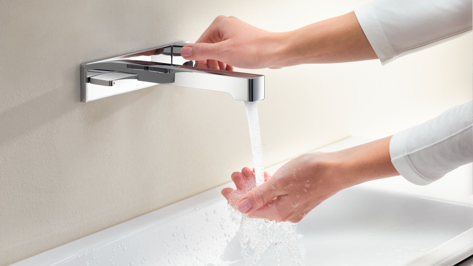 Makro-Aufnahme mit Händen, welche die Armatur Geberit ONE aufdrehen und Wasserstärke und -temperatur prüfen Makro-Aufnahme mit Händen, welche die Armatur Geberit ONE aufdrehen und Wasserstärke und -temperatur prüfen