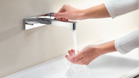 Makro-Aufnahme mit Händen, welche die Armatur Geberit ONE aufdrehen und Wasserstärke und -temperatur prüfen Makro-Aufnahme mit Händen, welche die Armatur Geberit ONE aufdrehen und Wasserstärke und -temperatur prüfen