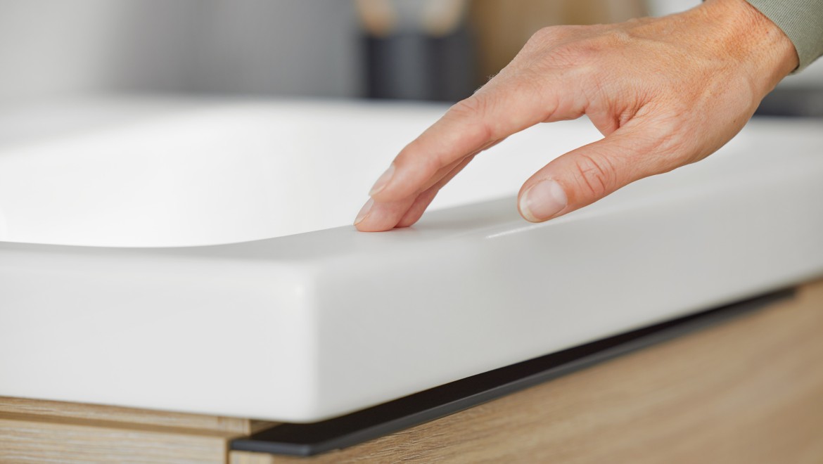 Makroaufnahme von Hand, die Waschtisch Geberit iCon in Weiss matt berührt Makroaufnahme von Hand, die Waschtisch Geberit iCon in Weiss matt berührt