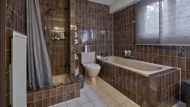 Badezimmer mit enger Duschecke, Badewanne und bodenstehendem WC