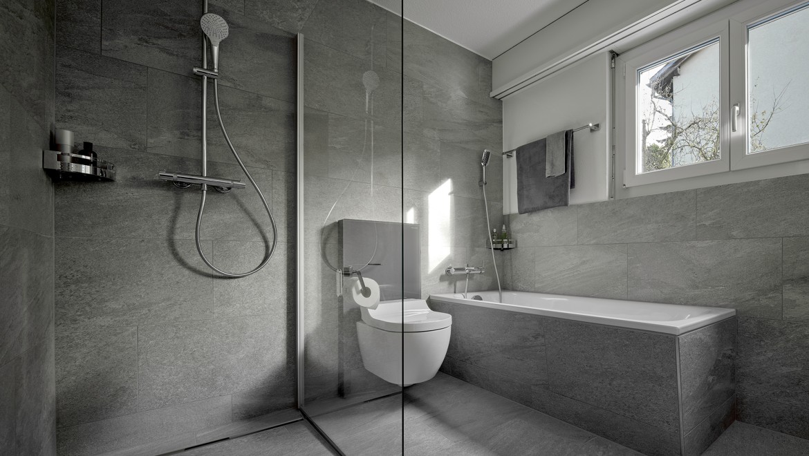 Ein Dusch-WC zwischen einer bodenstehenden Dusche und einer Badewanne Ein Dusch-WC zwischen einer bodenstehenden Dusche und einer Badewanne