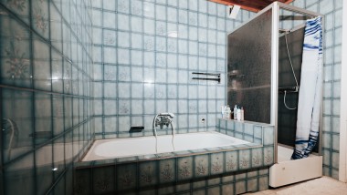 Bad mit blauen Fliesen, Duschkabine und Badewanne Bad mit blauen Fliesen, Duschkabine und Badewanne