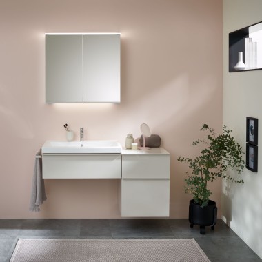 Ein Waschplatz mit Badmöbeln, Waschtisch und Spiegelschrank von Geberit vor einer pastellfarbenen Wand Ein Waschplatz mit Badmöbeln, Waschtisch und Spiegelschrank von Geberit vor einer pastellfarbenen Wand