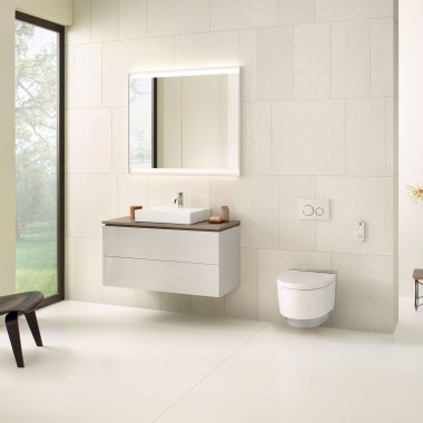 Ein Bad in Beige mit Spiegelschrank, Waschtischunterschrank, Betätigungsplatte und Keramiken von Geberit