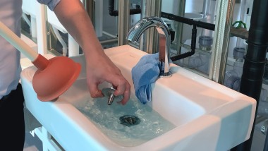 Siphondeckel im Waschbecken wird entfernt Siphondeckel im Waschbecken wird entfernt