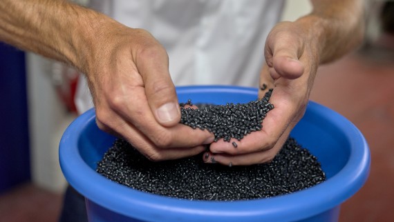 Hände, die schwarze Kunststoff-Pellets halten (© Ben Huggler) Hände, die schwarze Kunststoff-Pellets halten (© Ben Huggler)