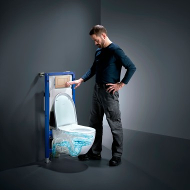 Mann neben Geberit Acanto-WC mit TurboFlush, neuem Geberit Duofix und Betägigungsplatte Sigma40 in Rotgold Mann neben Geberit Acanto-WC mit TurboFlush, neuem Geberit Duofix und Betägigungsplatte Sigma40 in Rotgold