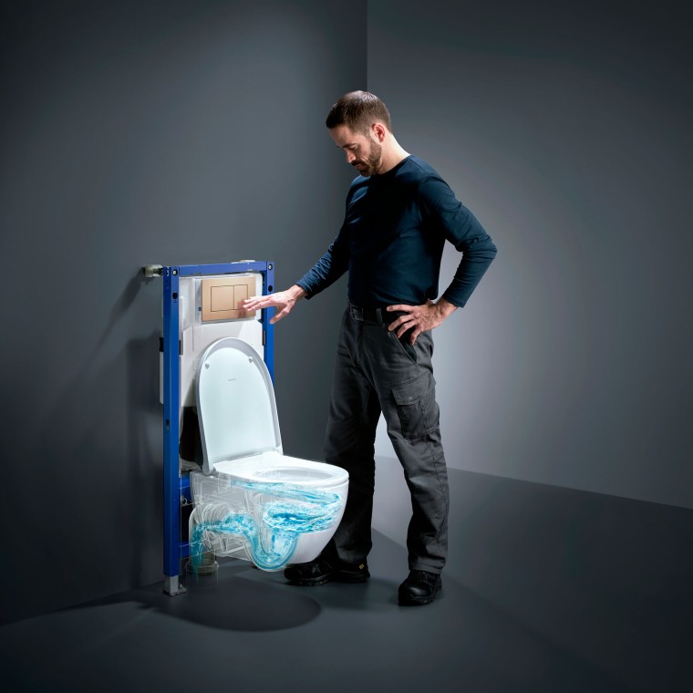 Mann neben Geberit Acanto-WC mit TurboFlush, neuem Geberit Duofix und Betägigungsplatte Sigma40 in Rotgold Mann neben Geberit Acanto-WC mit TurboFlush, neuem Geberit Duofix und Betägigungsplatte Sigma40 in Rotgold