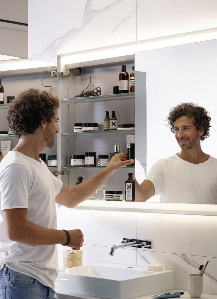 Mann in einem Badezimmer mit Geberit ONE Spiegelschrank Mann in einem Badezimmer mit Geberit ONE Spiegelschrank
