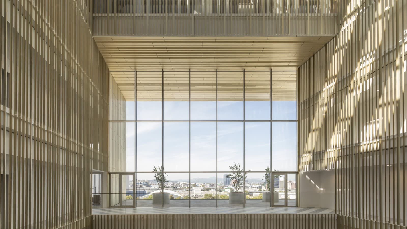 Das Atrium ist mit vergoldeten Aluminiumprofilen verkleidet, deren Farbtöne sich je nach Sonnenstand verändern (© Ana Skobe) Das Atrium ist mit vergoldeten Aluminiumprofilen verkleidet, deren Farbtöne sich je nach Sonnenstand verändern (© Ana Skobe)